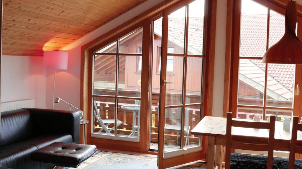 a living room with a table and a large window at Bavaria in Seeg
