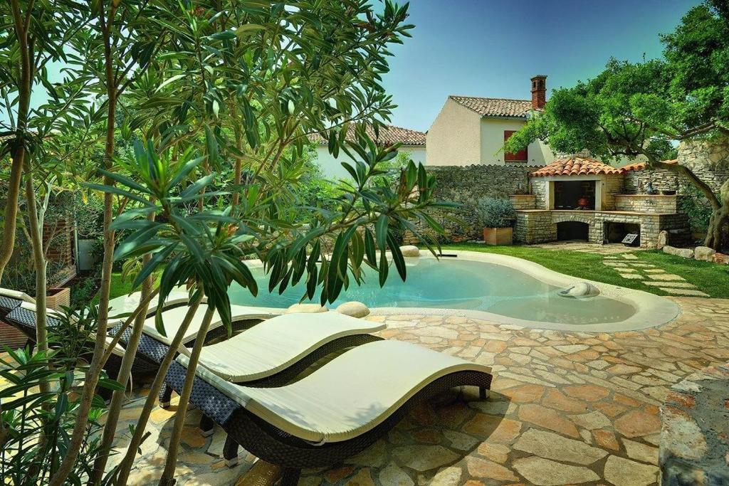 a swimming pool with a couch next to a house at Villa BR in Ližnjan