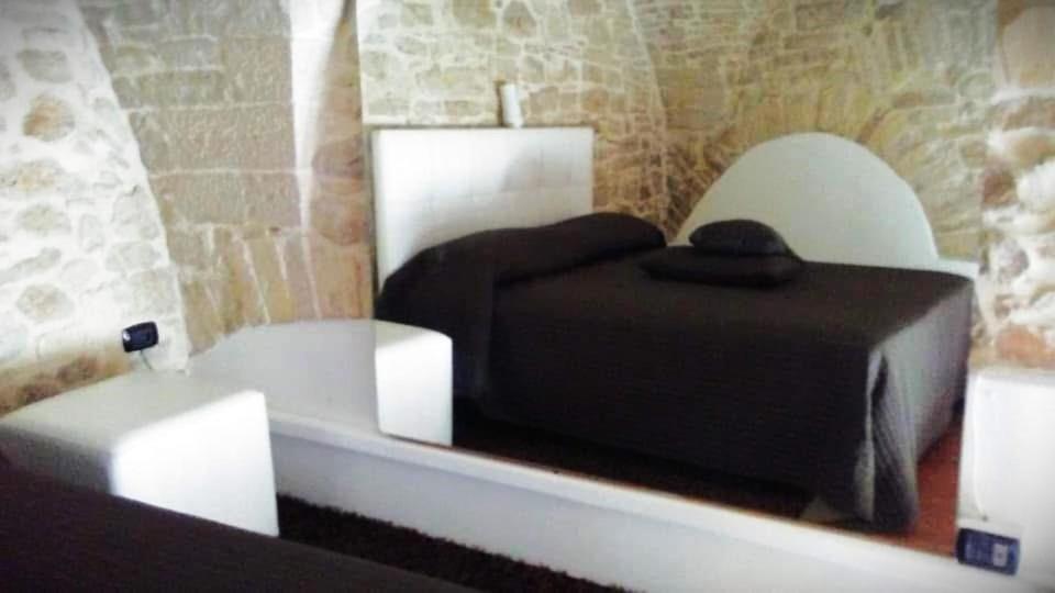 a bedroom with a black bed and two white chairs at B&B La Dimora in Corato