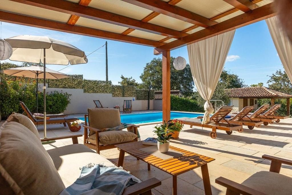 a patio with chairs and a swimming pool at Villa Lasa in Pazin