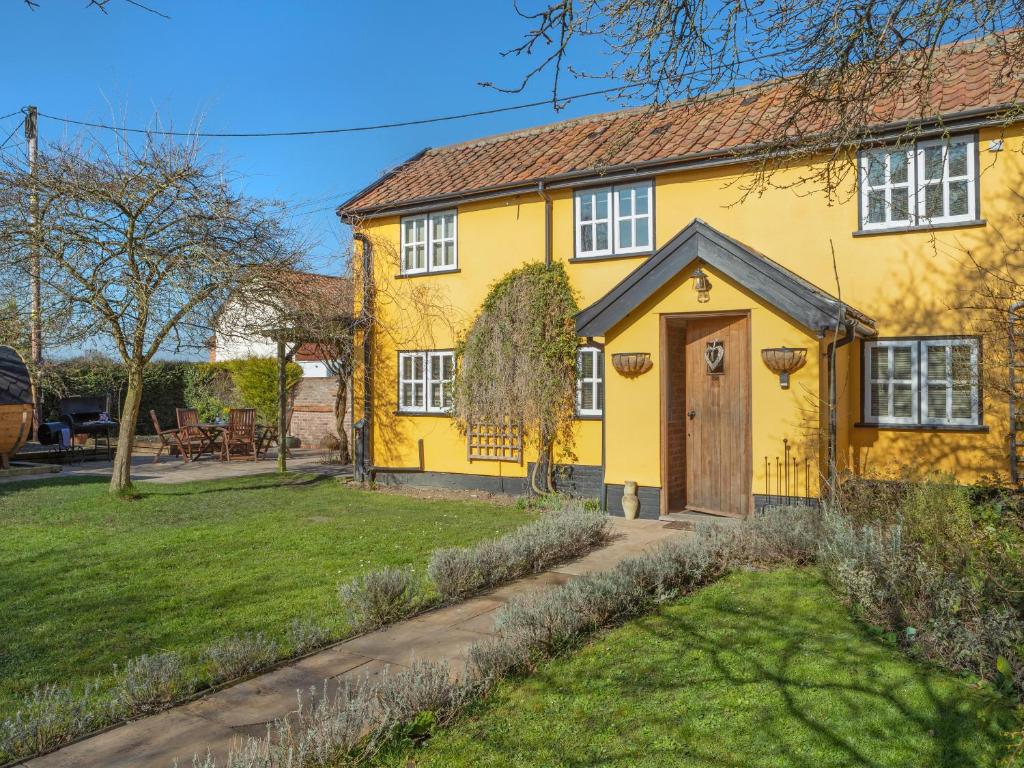 a yellow house with a door and a yard at Lavender Cottage - Ukc9687 in Thorndon