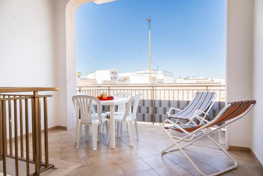 a balcony with a table and chairs and a view at Appartamento Sunny by ThePuglia in Torre Lapillo