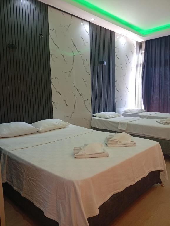 two beds in a hotel room with towels on them at Barış Otel in Didim