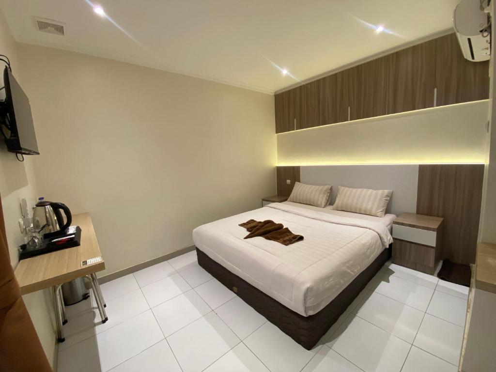 a bedroom with a white bed in a room at Hotel Paris Santika in Rawara