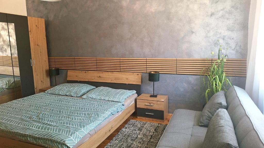 a bedroom with a bed and a couch at Apartmán CENTRAL, near the center, self check in 24 h, free parking in Banská Bystrica