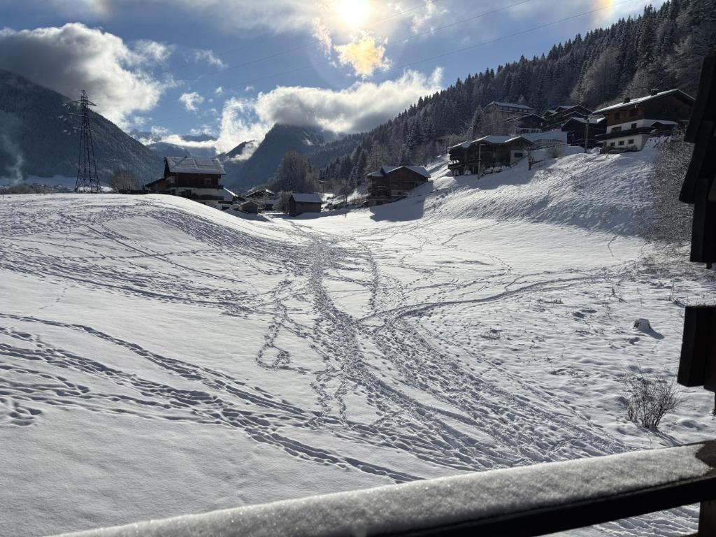 a snow covered ski slope with the sun in the background at Le repère du Nant- meublé classé 2 étoiles in Morzine