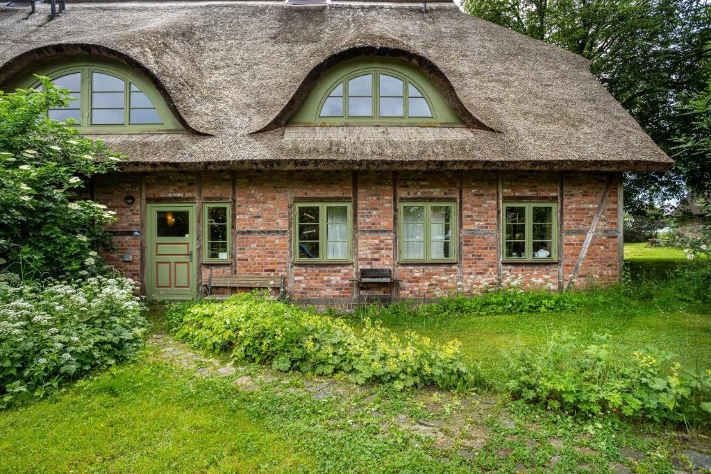 a small brick house with a thatched roof at Alte Scheune in Putbus