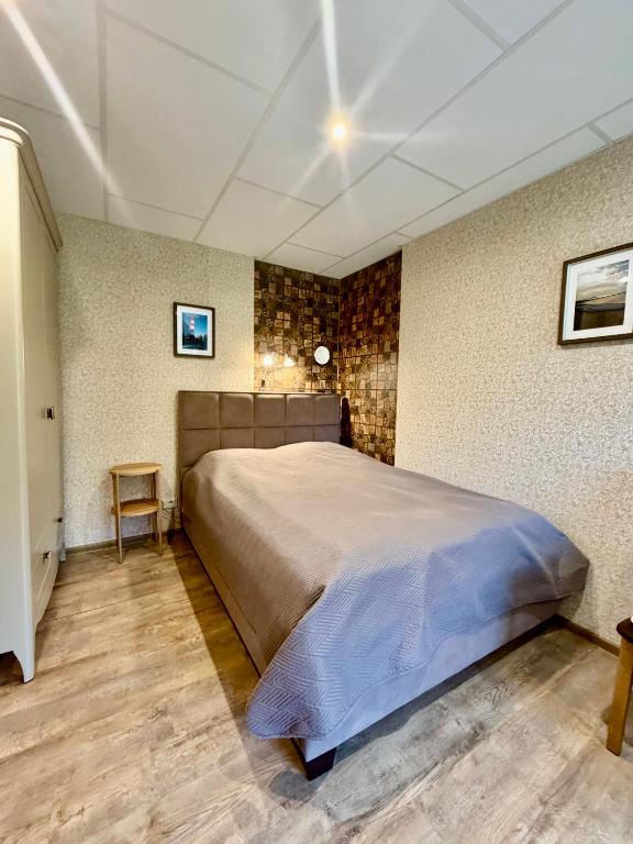 a bedroom with a large bed in a room at Butas Prie Kaštono in Nida