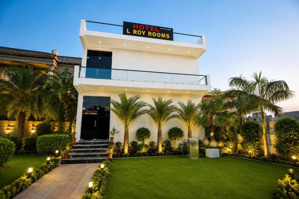 a hotel with a lawn in front of a building at L Roy in Meerut