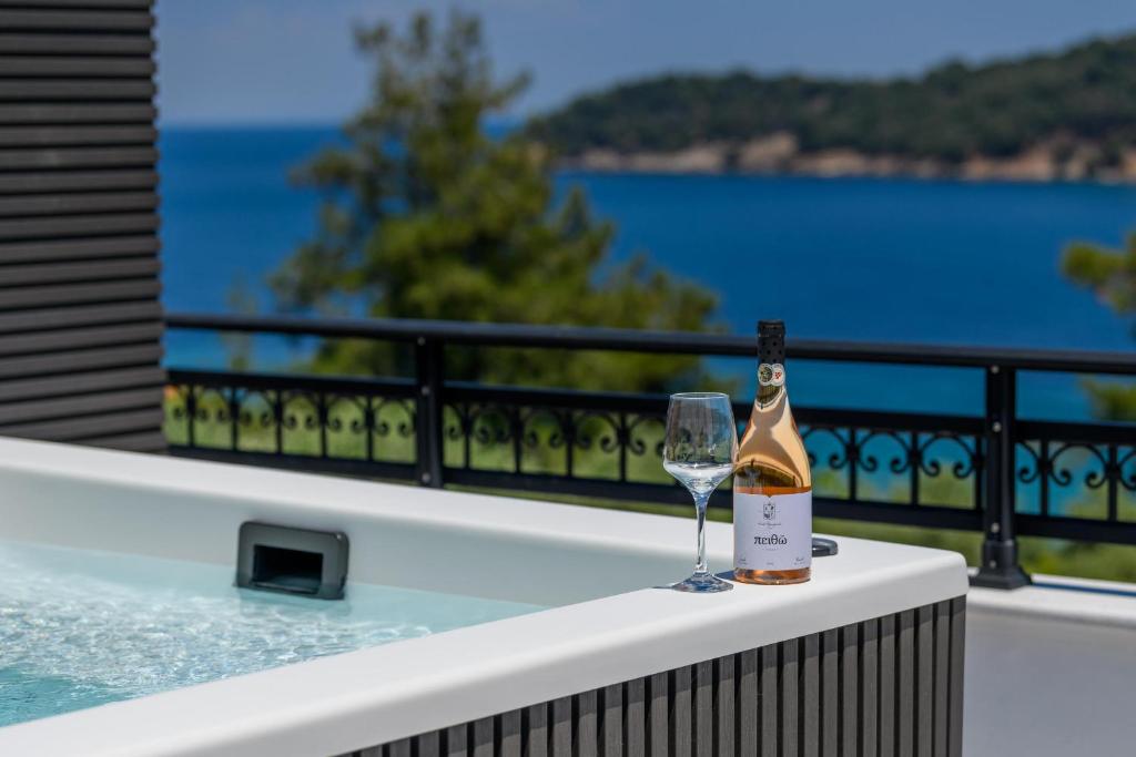 a bottle of champagne and a wine glass on a balcony at Olea Mare Suites in Koinyra