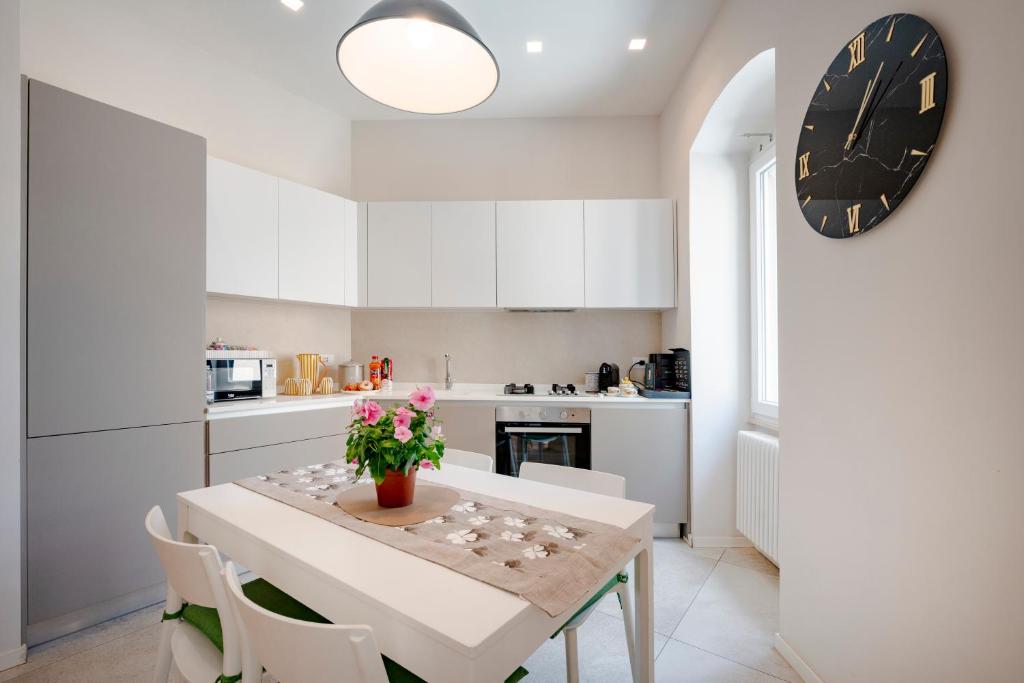 a kitchen with a table with a vase of flowers on it at Martini Matera 2-luxury apartment in Matera