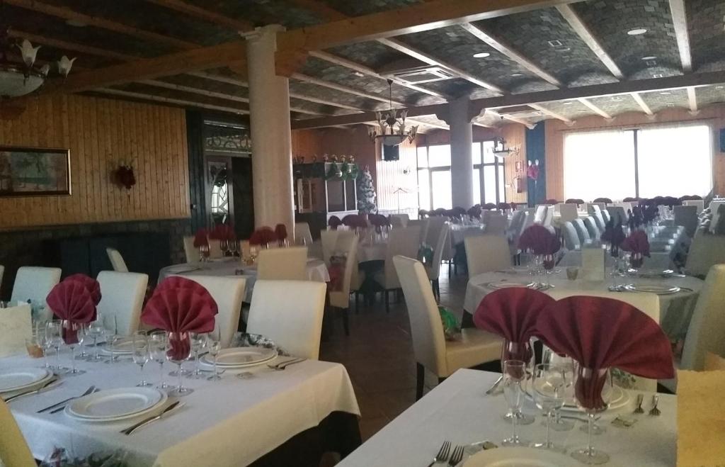 un comedor con mesas blancas y sillas blancas en Hotel Gardu, en Montealegre del Castillo