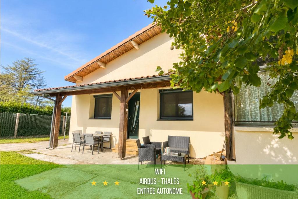 a house with a patio and chairs in a yard at " Sweet Home " Jardin - 4 ch - Wifi - Thalès in Cugnaux