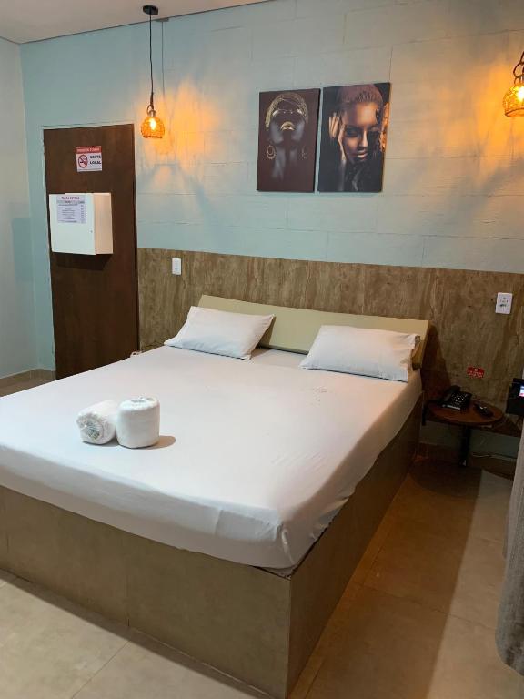 a large bed in a room with two towels on it at Rota 69 motel in Porto Nacional