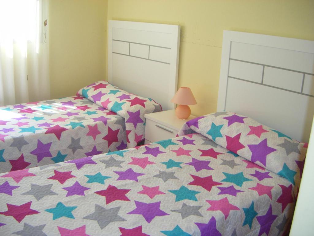 2 camas individuales en una habitación con estrellas en Apartamentos Espejo, en Los Alcázares
