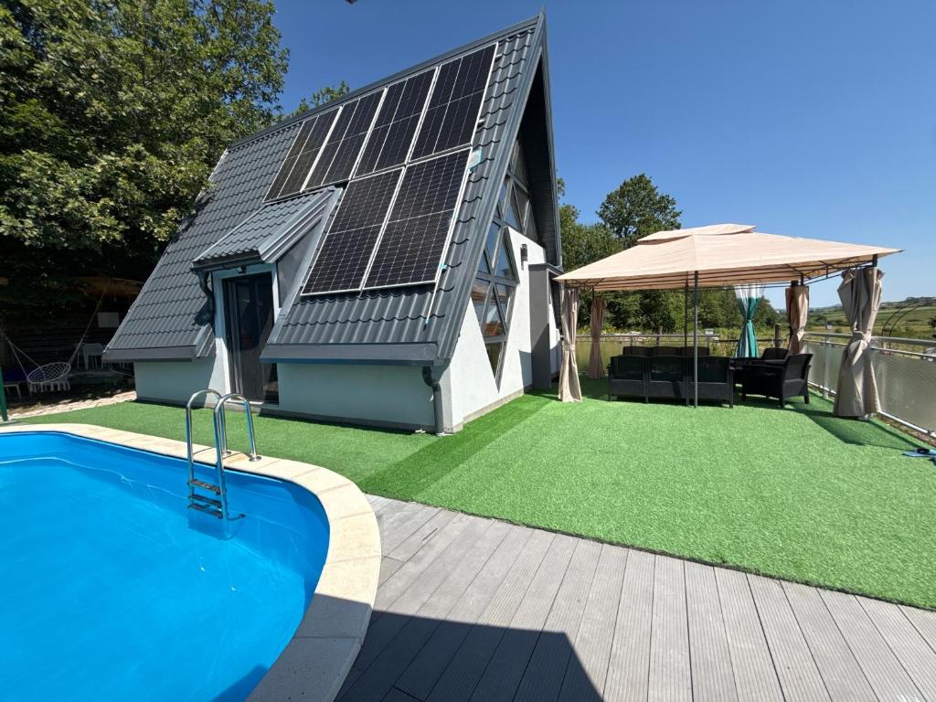 a house with solar panels on the roof at 1001 Noc Cazin - Oaza prirode i odmora in Mutnik