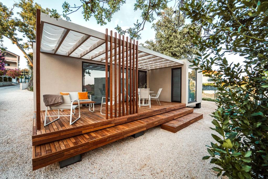 a small house with a deck with a table and chairs at Modern Seaside House in Pakoštane
