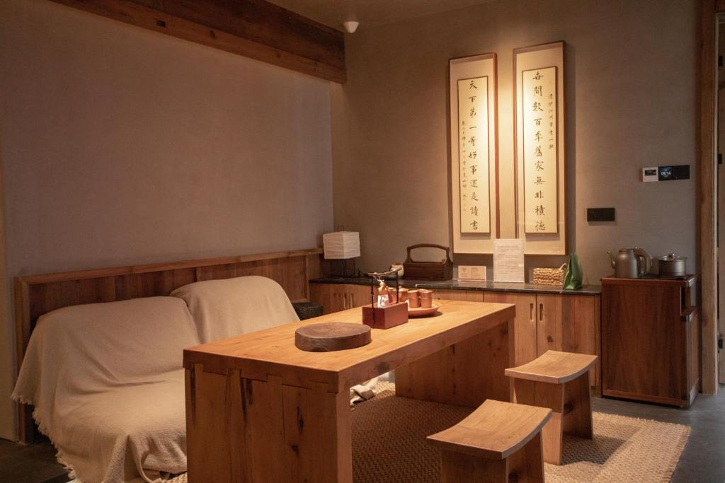 a room with a bed and a wooden table at 忘寂民宿 in Zhangjiajie