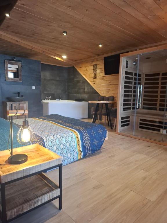 a bedroom with a bed and a table at Chambre de luxe spa eden in Sainte-Ode