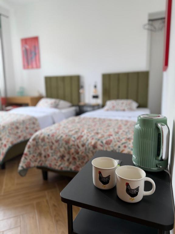two cups on a table in a room with two beds at Szumi Las Bed & Breakfast in Józefów