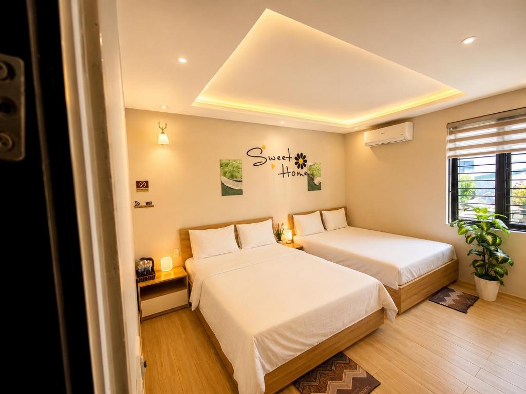 a bedroom with two beds and a window at Pi Home in Dong Hoi