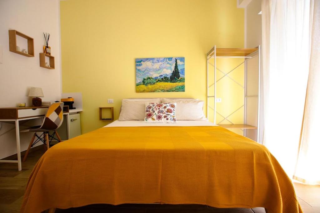 a bedroom with a bed with a yellow blanket at Pole Pole - SOLE in Agropoli