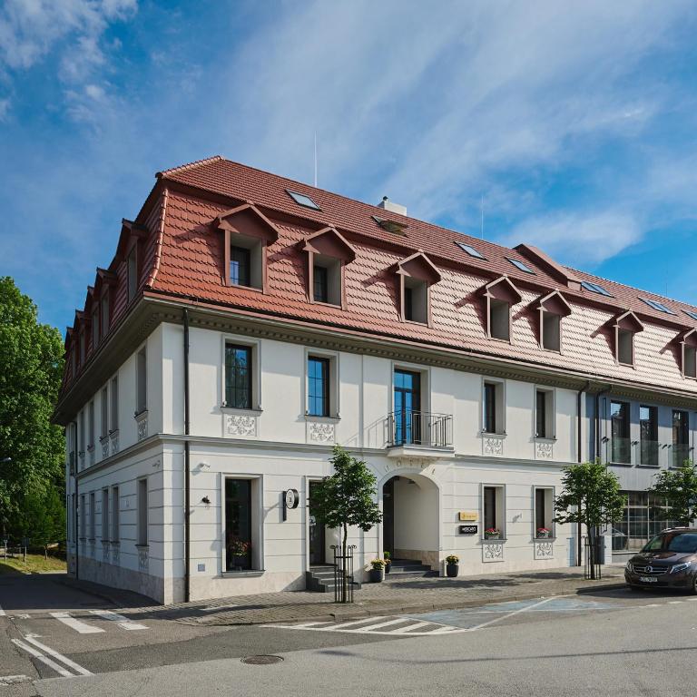 a large white building with a red roof at Hotel Zator in Zator