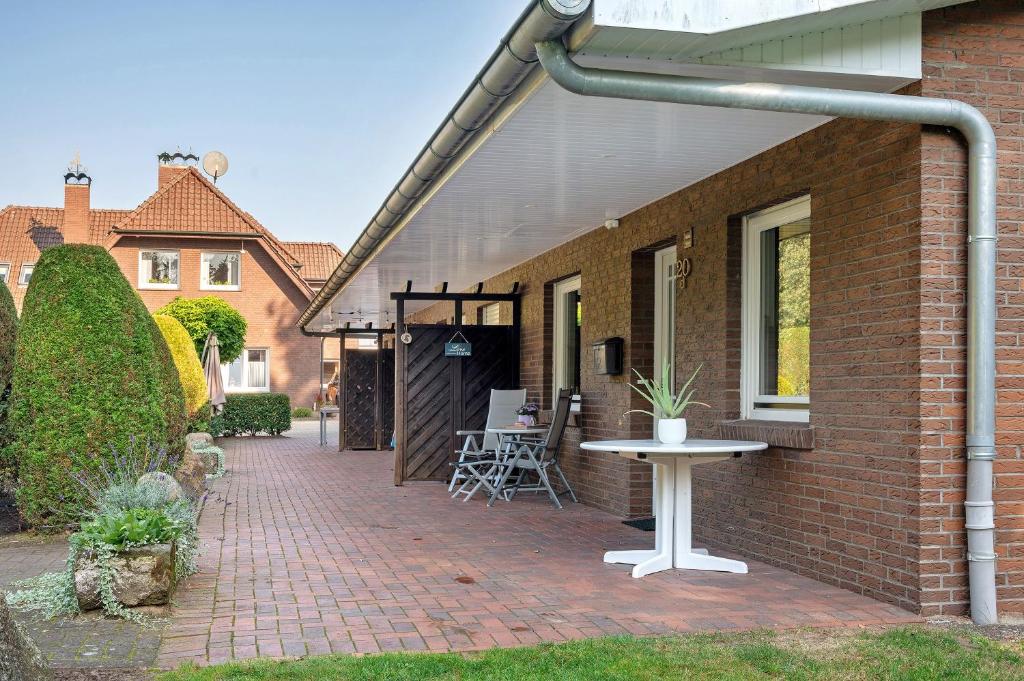 a brick house with a patio with a table at Ferienwohnung Bahlmann in Garrel
