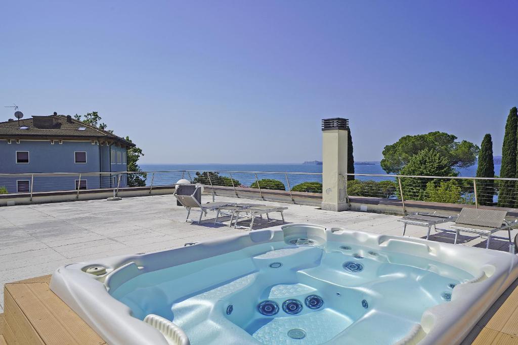 a jacuzzi tub sitting on a patio next to the ocean at Corte Fasanella 33 in Toscolano Maderno