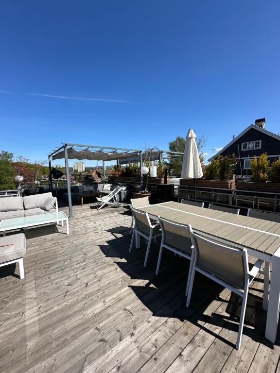 a patio with a table and chairs and an umbrella at Moderne enebolig, sentralt in Oslo