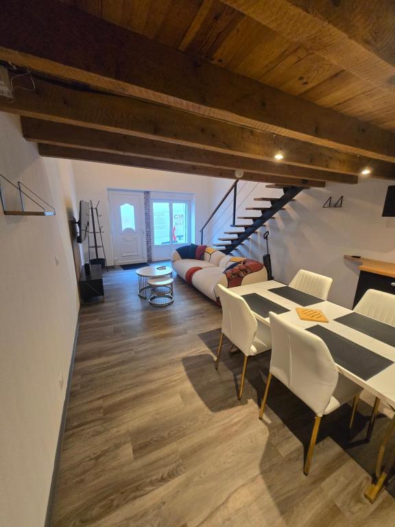 a living room with a table and chairs and a couch at Le calme in La Souterraine