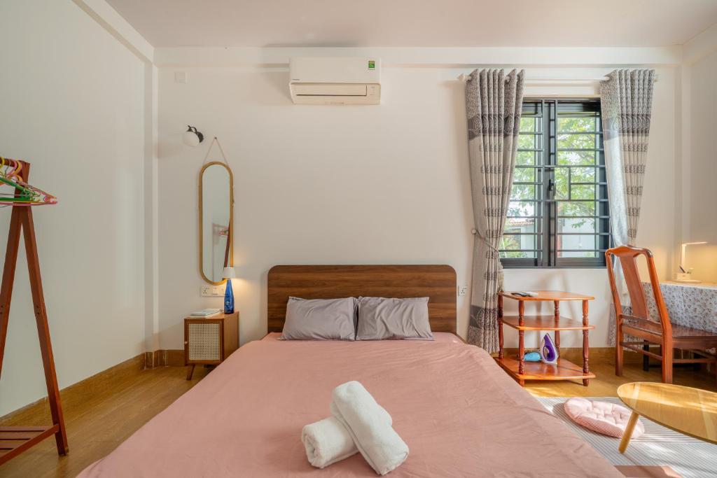 a bedroom with a bed with two towels on it at Live like a local Homestay in Ấp Tư Tây
