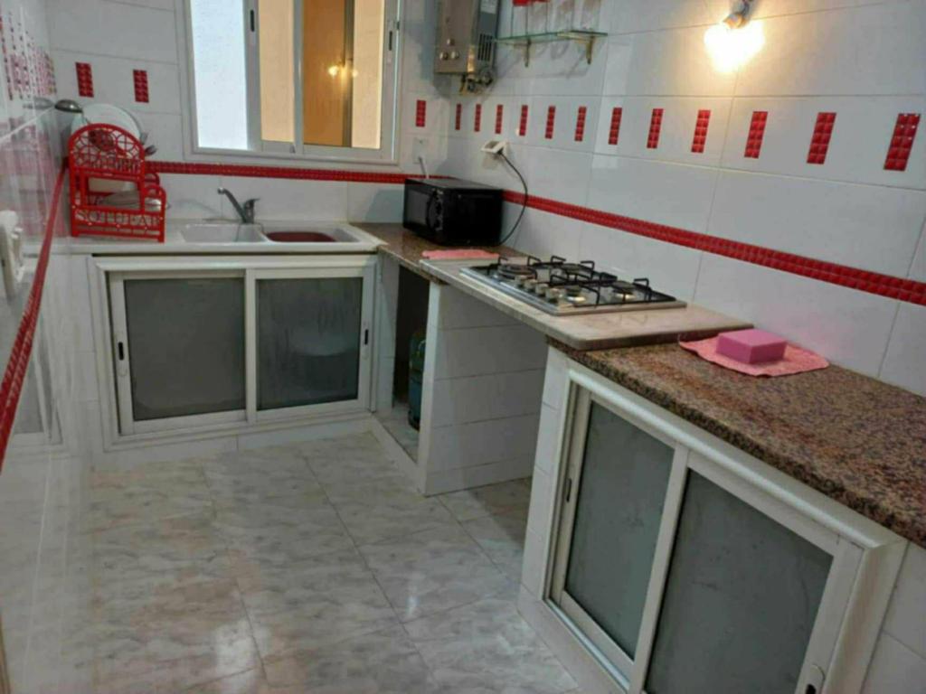 a small kitchen with a stove and a sink at Dar chat in Kelibia