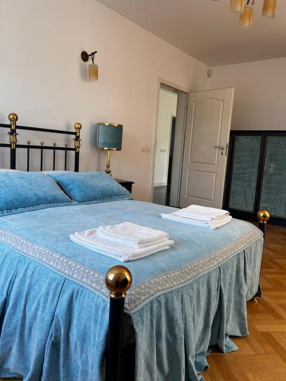 a bedroom with a blue bed with two towels on it at Apartament Krzemienna in Bielsko-Biała