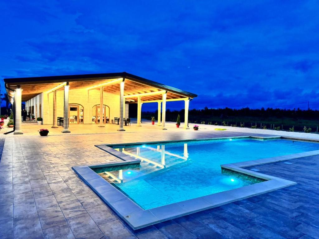 a swimming pool at night with a pavilion at Agriturismo Tenuta Santarcangelo in Scanzano