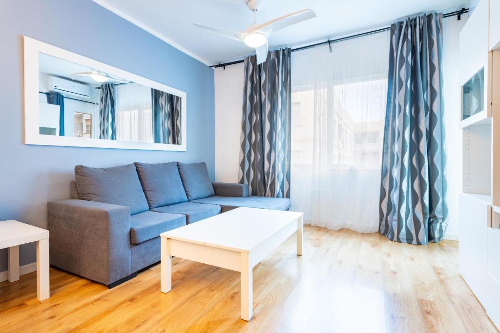 a living room with a blue couch and a table at Apartamento Caracola in Vinarós