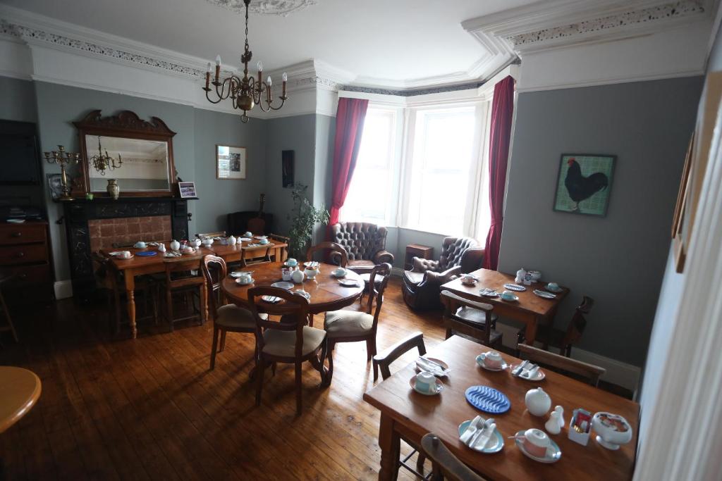 a living room with tables and chairs and a dining room at Rolling Wave Guesthouse in Bundoran