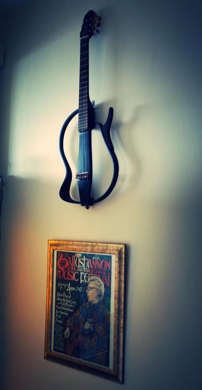 a guitar hanging on a wall next to a picture at Rolling Wave Guesthouse in Bundoran