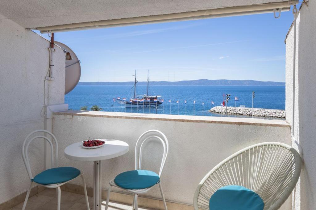 a balcony with a table and chairs and a view of the ocean at Apartment Amfora in Podgora