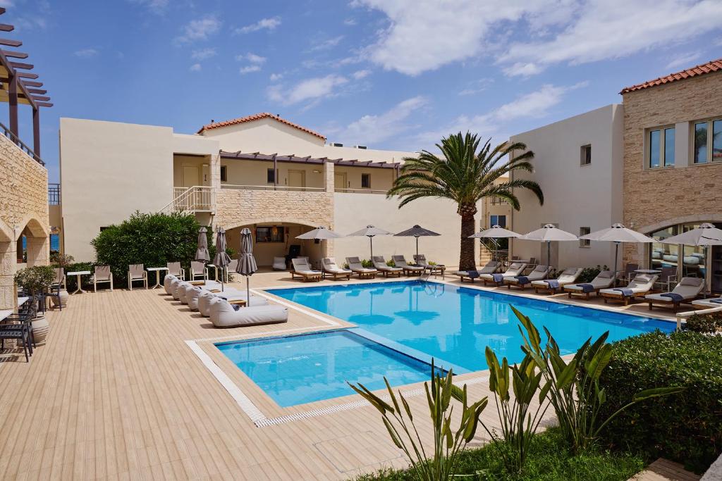 a pool at a hotel with chairs and umbrellas at Maravel Star Art Hotel in Adelianos Kampos