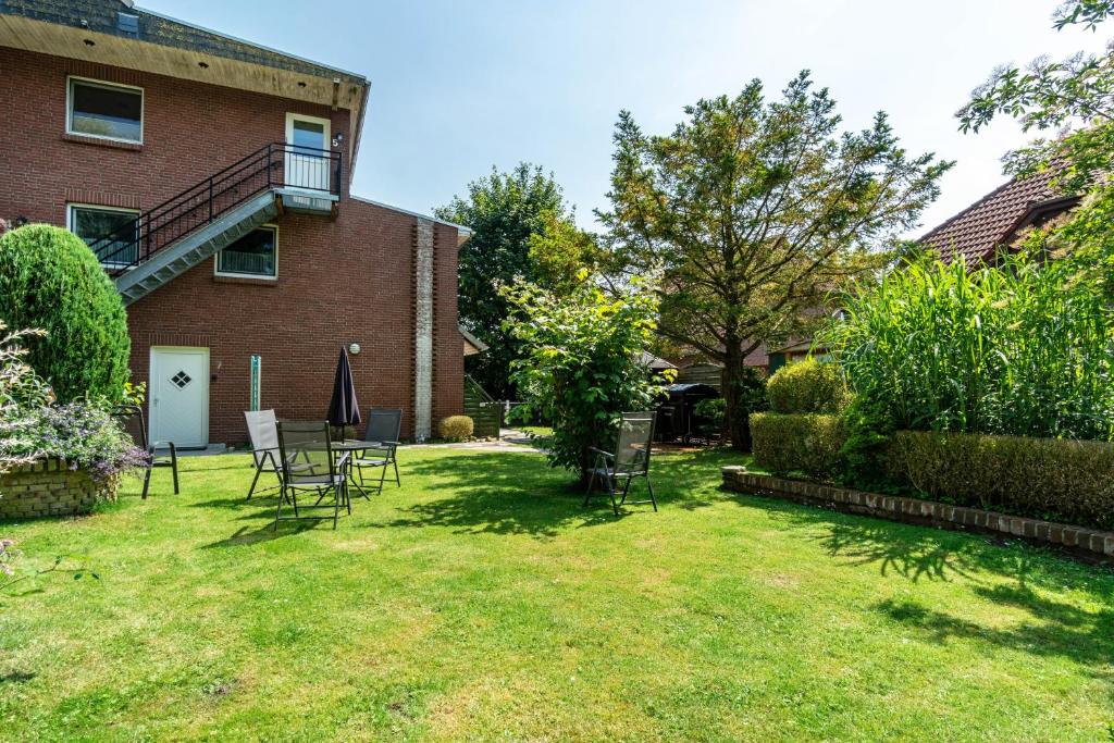 a yard with chairs and a building at Ferienwohnung Grodenblick in Hooksiel