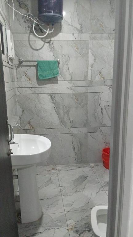 a bathroom with a sink and a white toilet at Hotel Sunray in Tarn Tāran