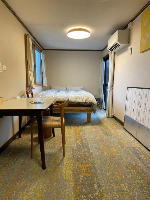 a room with a bed and a table and a desk at Popotel 3 Shaking Secret Room in Matsumoto