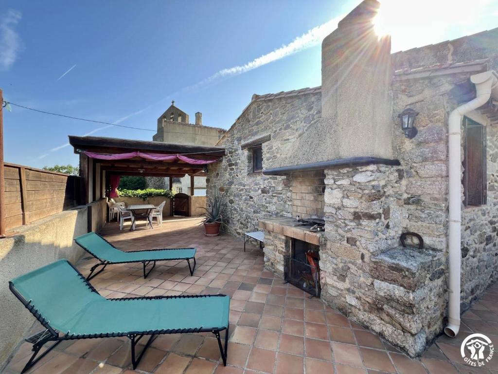 a patio with two chairs and a stone fireplace at Rafael in Quintillan