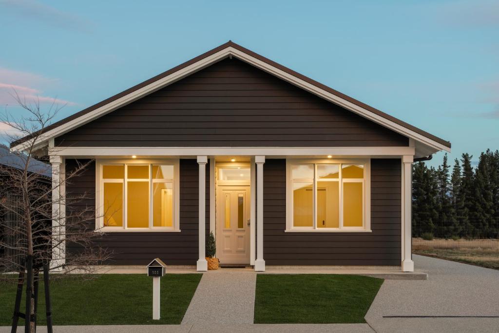 a black house with a front door and windows at Modern home, old charm! in Lake Hāwea