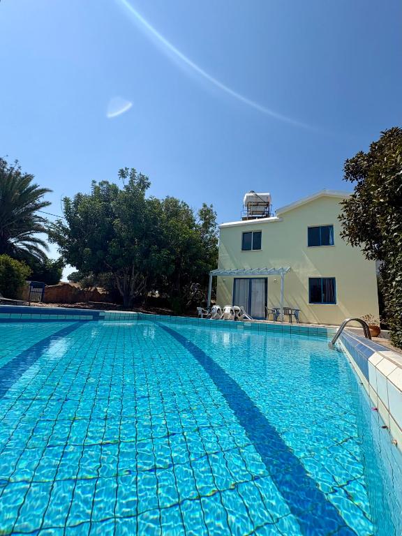 a swimming pool in front of a house at Queen Evridiki in Peyia
