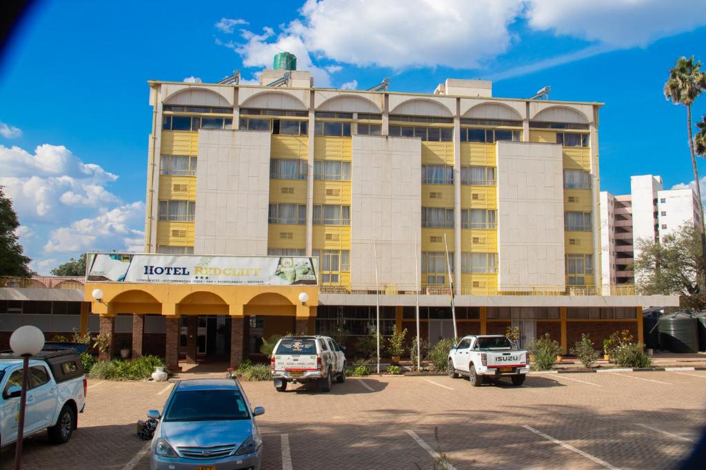 a hotel with cars parked in a parking lot at Hotel Redcliff in Redcliff