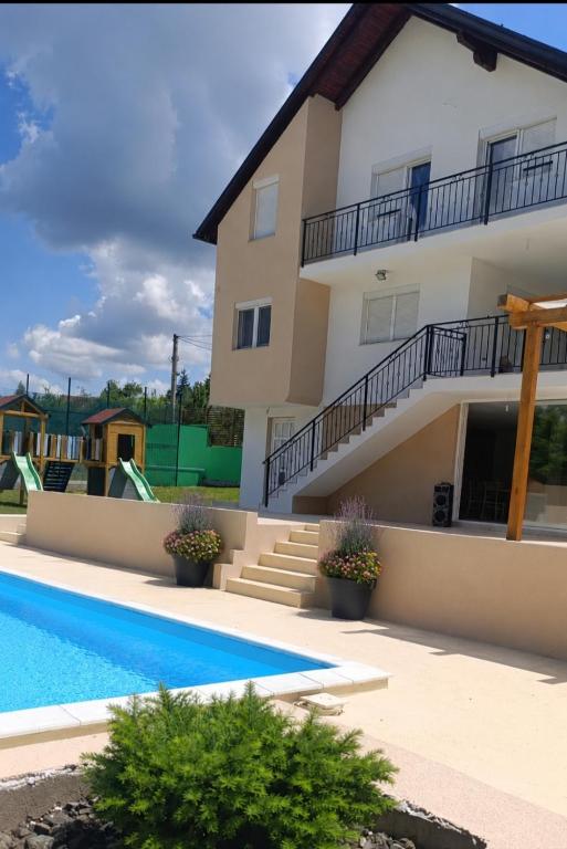 a house with a swimming pool and a building at Villa Tri tačke in Debeljaci