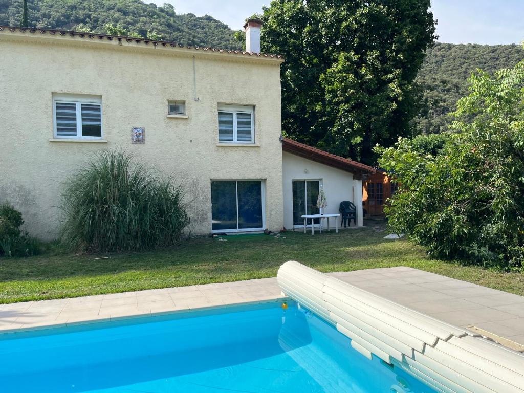 a house and a swimming pool in front of a house at Logis Sol Levante in Arles-sur-Tech