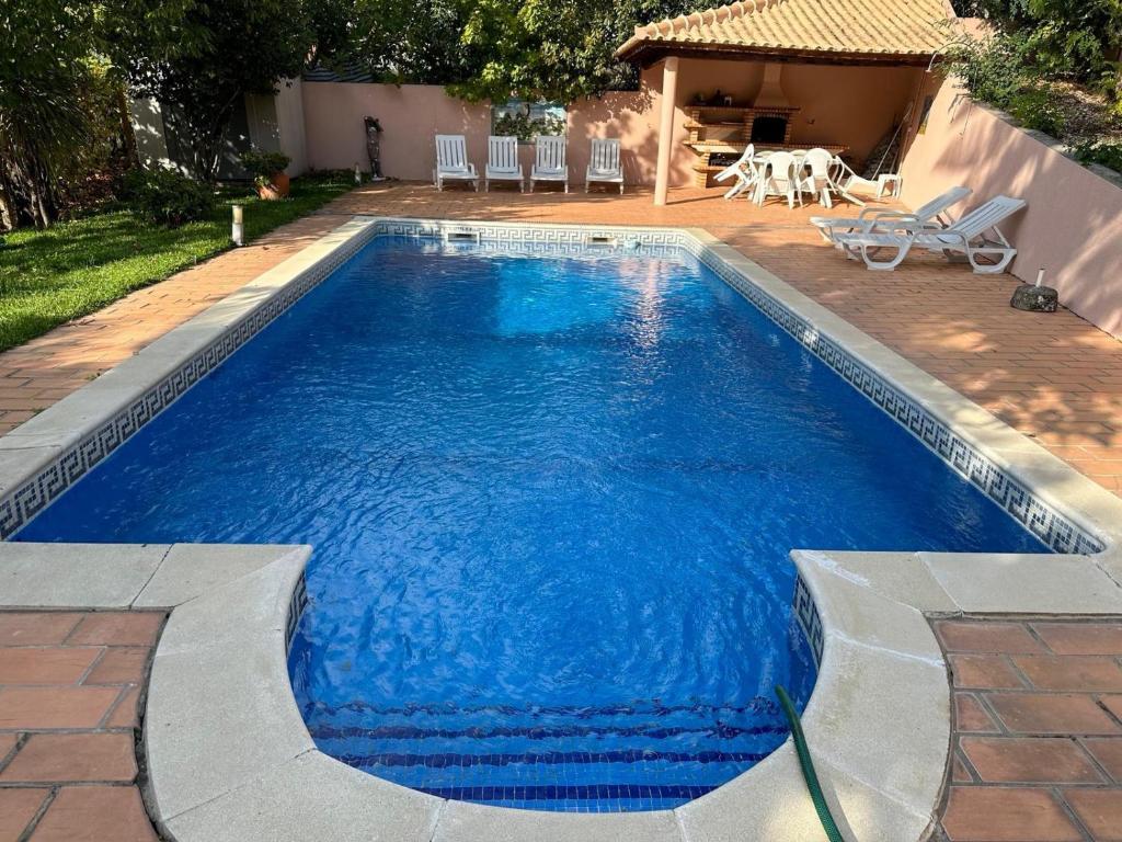 a swimming pool with blue water in a yard at Casa Loureiro - Vista Rio Douro in Resende